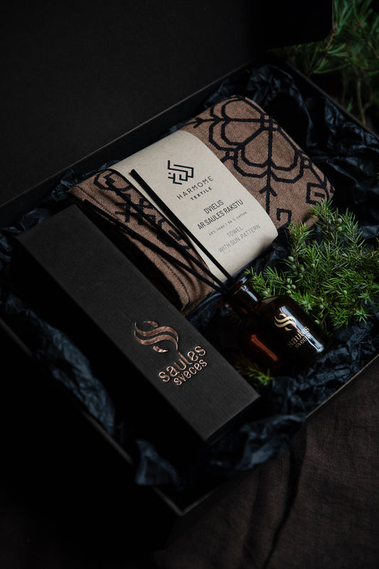 Dāvanu komplekts ar dvieli ar saules rakstu un mājas aromātu, skaisti iepakotu kastē no HarmoMe.