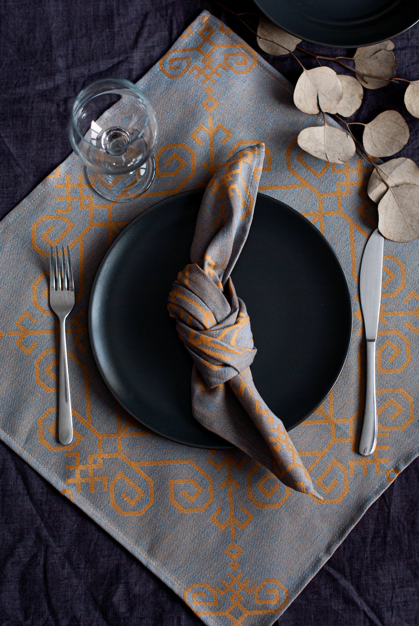 Lina salvete ar iestrādātu Saules mandalas rakstu, rādīts ar galda klājumu sasietā dizainā no HarmoMe.