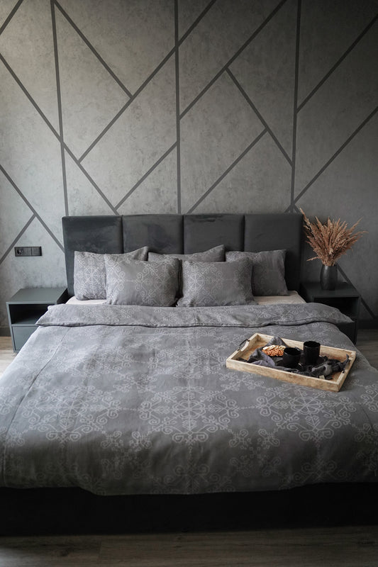 Lina un kokvilnas gultas veļa ar Saules mandalas rakstu, saklātā gultā un ar paplāti uz tās no HarmoMe.