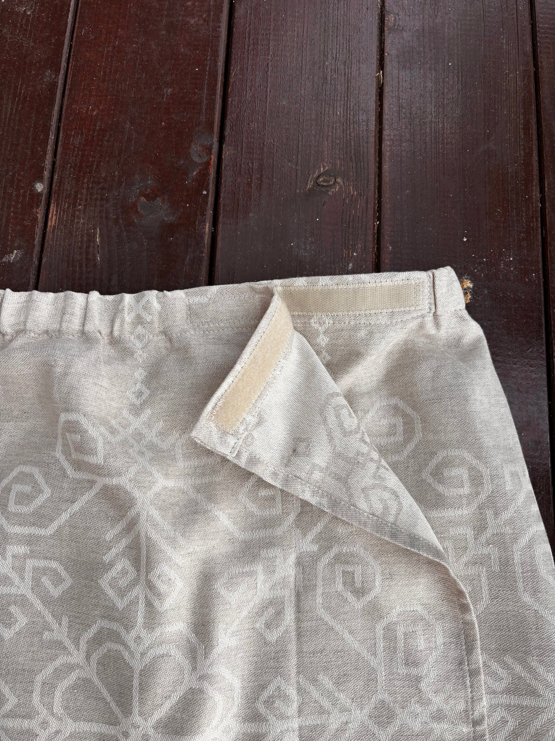 Regulējams pirts dvielis ar lipekli vīrietim un sievietei pirts rituālos ar latviešu un baltu spēka zīmēm