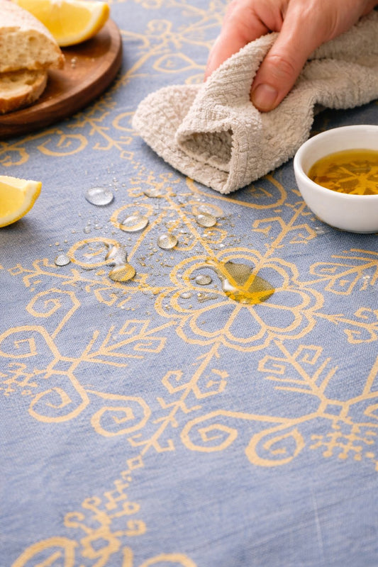 Ūdeni atgrūdošs abpusējs galdauts ar Saules rakstu, pelēkzils ar zeltainu rakstu.