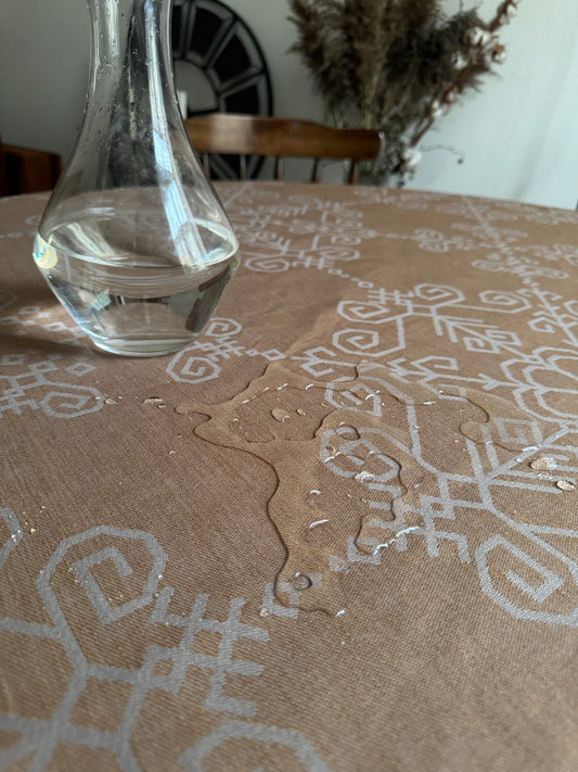 Ūdeni atgrūdošs abpusējs galdauts ar Saules rakstu, bēšs ar pelēku rakstu.